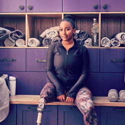 Hollard disability cover client with a prosthetic leg sitting on a bench in the gym locker room